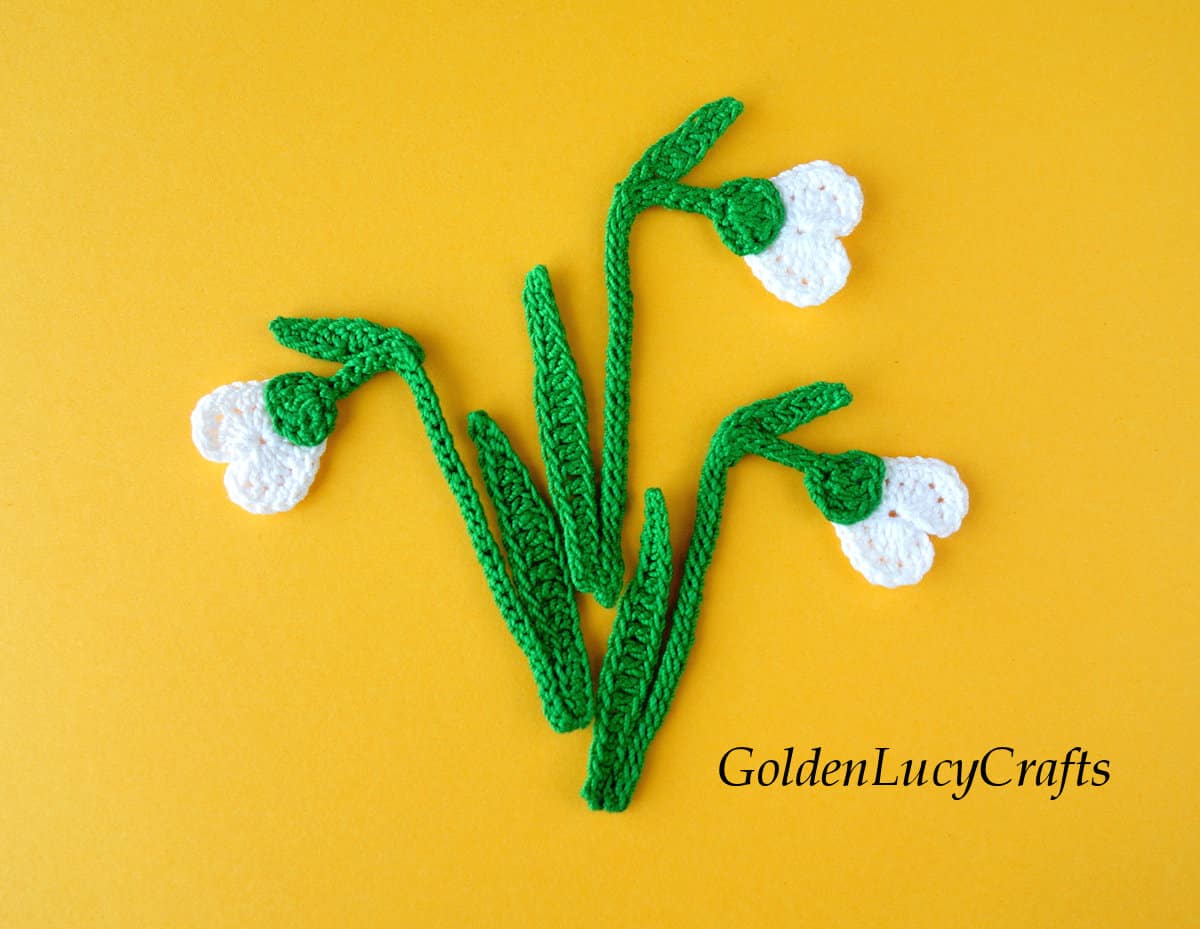 Crochet snowdrop applique on yellow background.