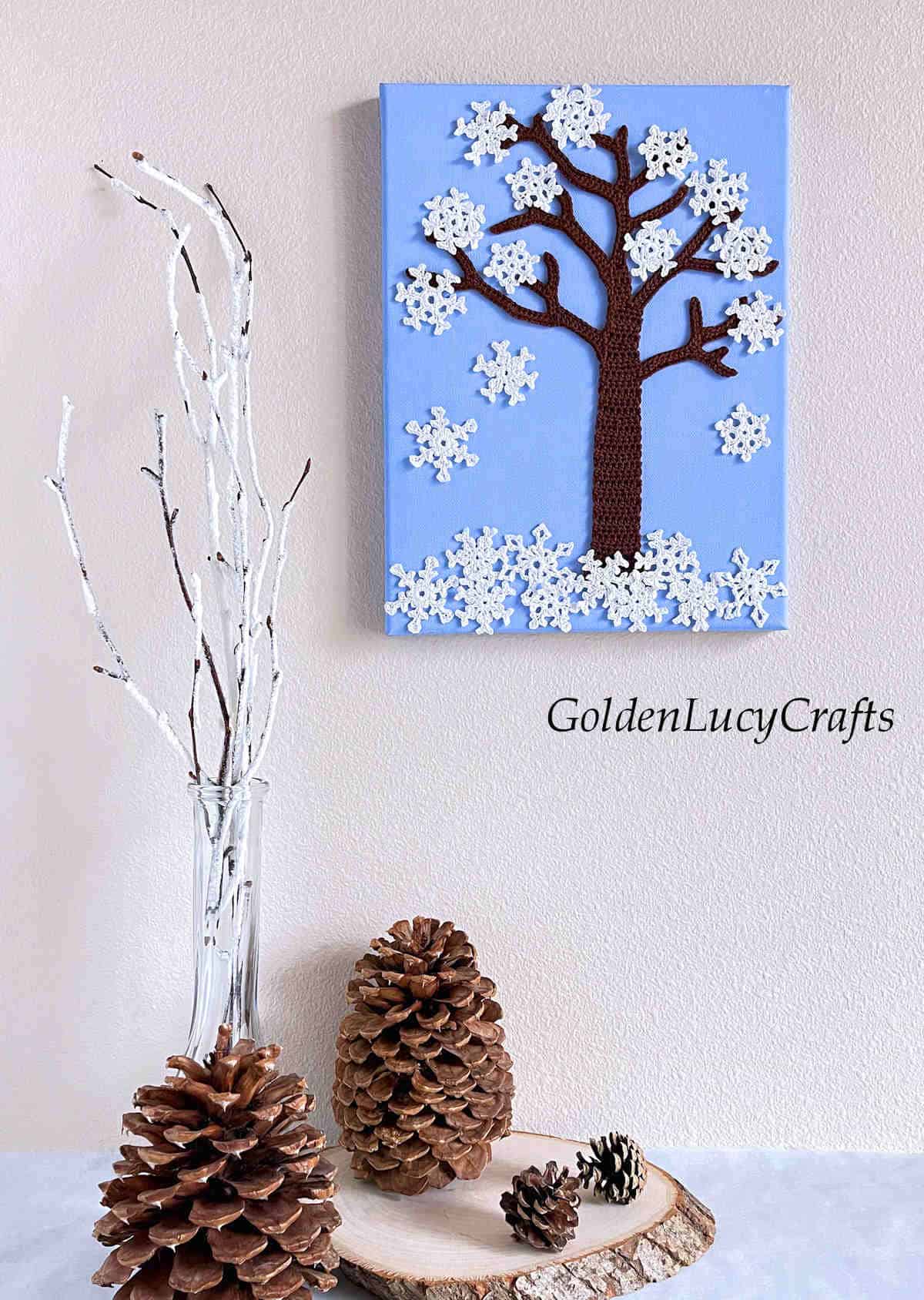 Crochet winter tree on canvas hanging on the wall.