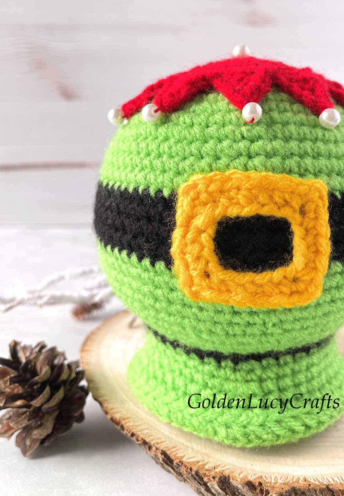 Crochet elf belly snow globe close up image.