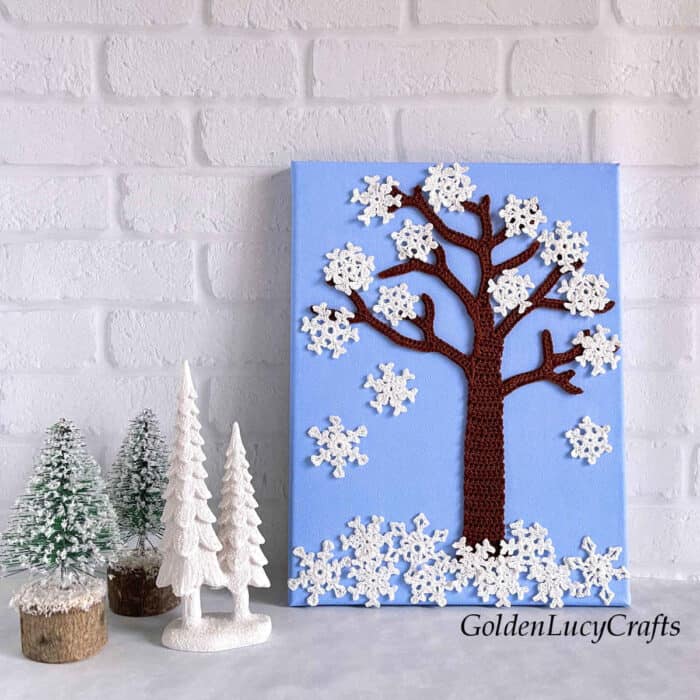Tree covered in snowflakes crochet wall art.