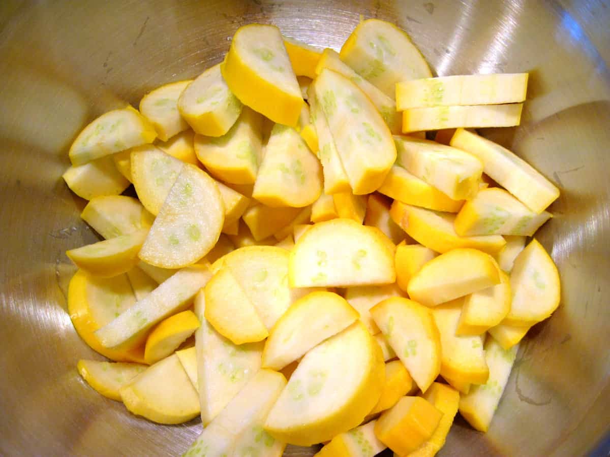 Sliced squash in a mixing bowl.
