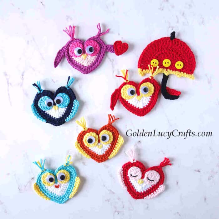 Six crocheted heart-shaped owl appliques, one of them has an umbrella.
