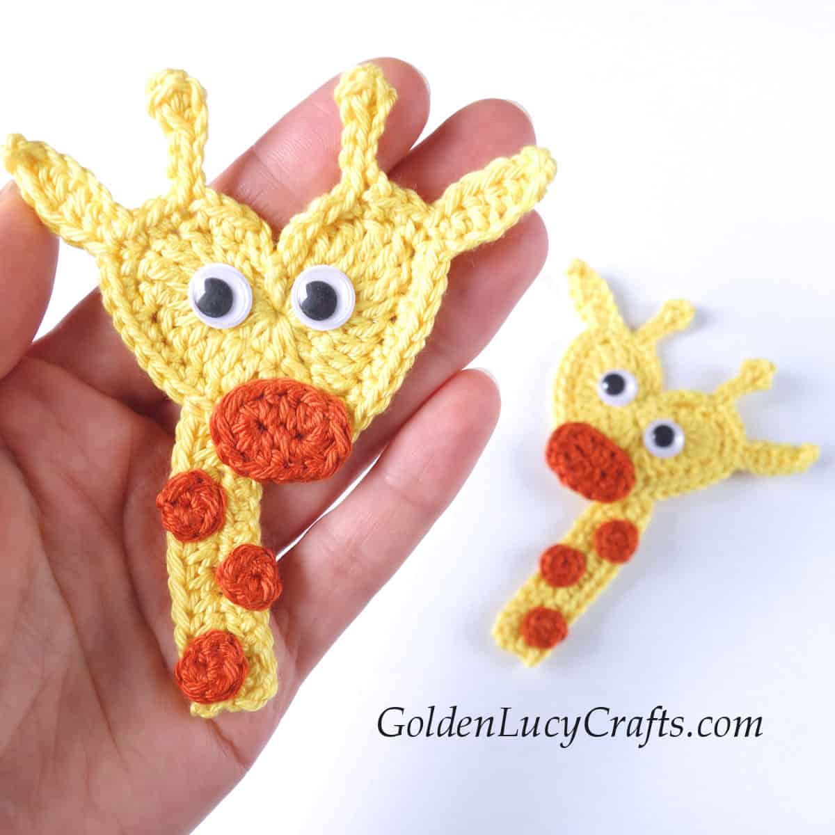 Crochet giraffe applique in the palm of a hand.