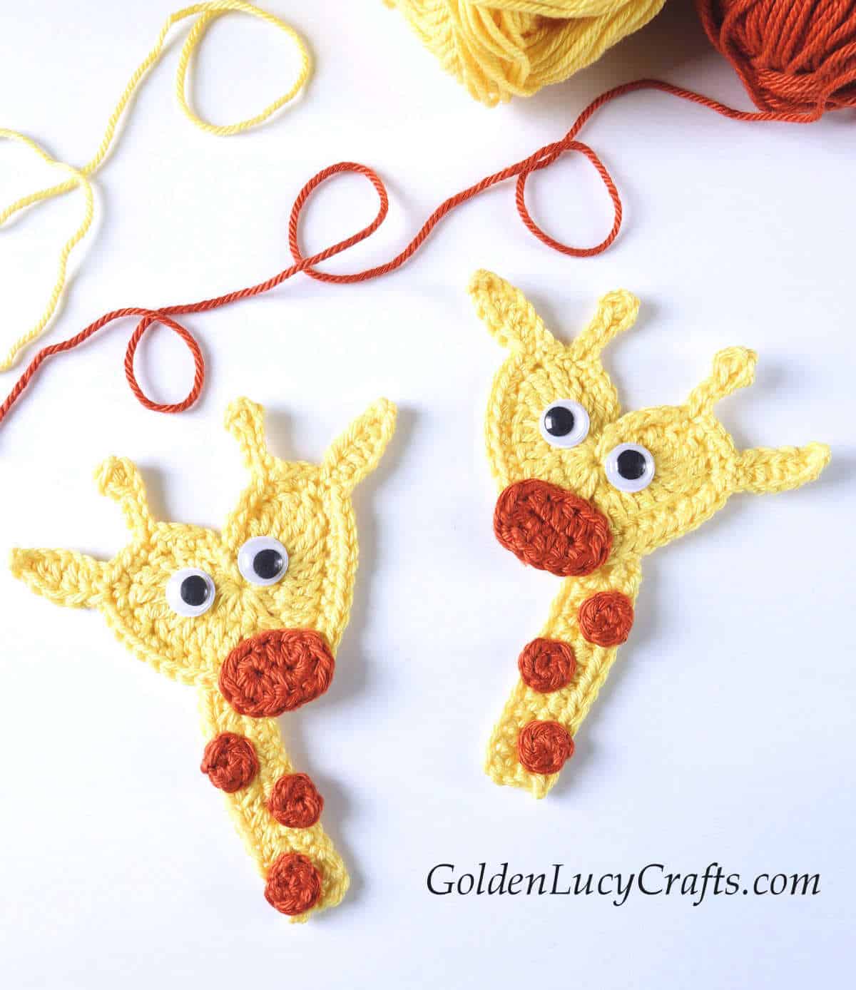 Two crocheted giraffe appliques with googly eyes.