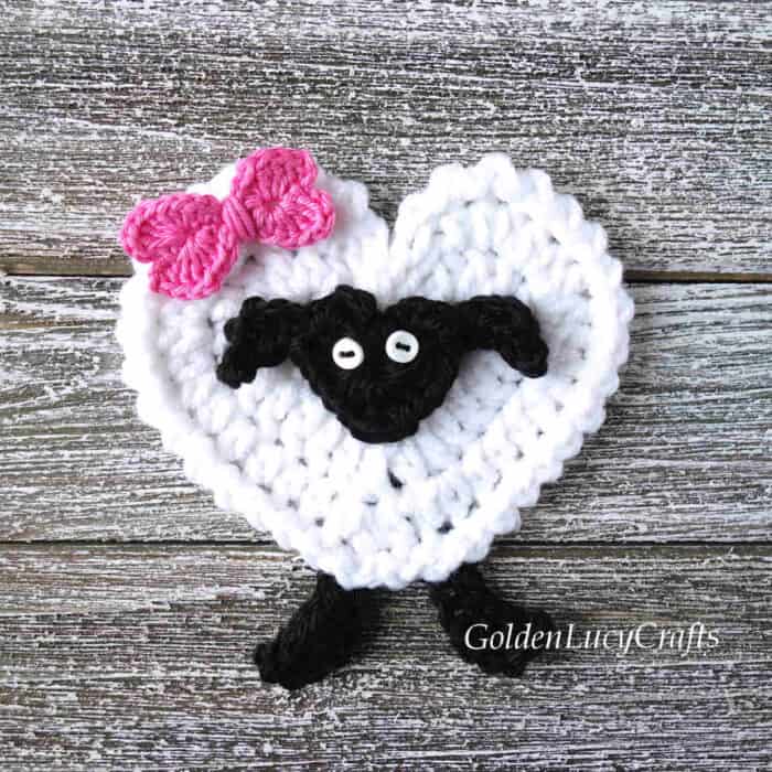 Crochet applique sheep with pink bow.