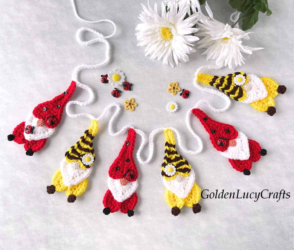 Crochet garland or bunting made from bee and ladybug gnomes.