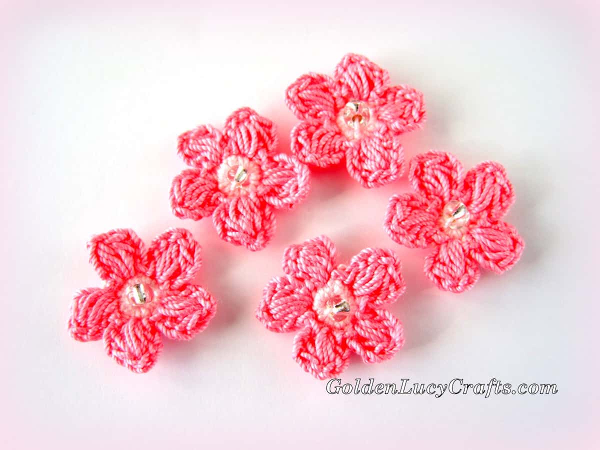 Five crocheted pink flowers.