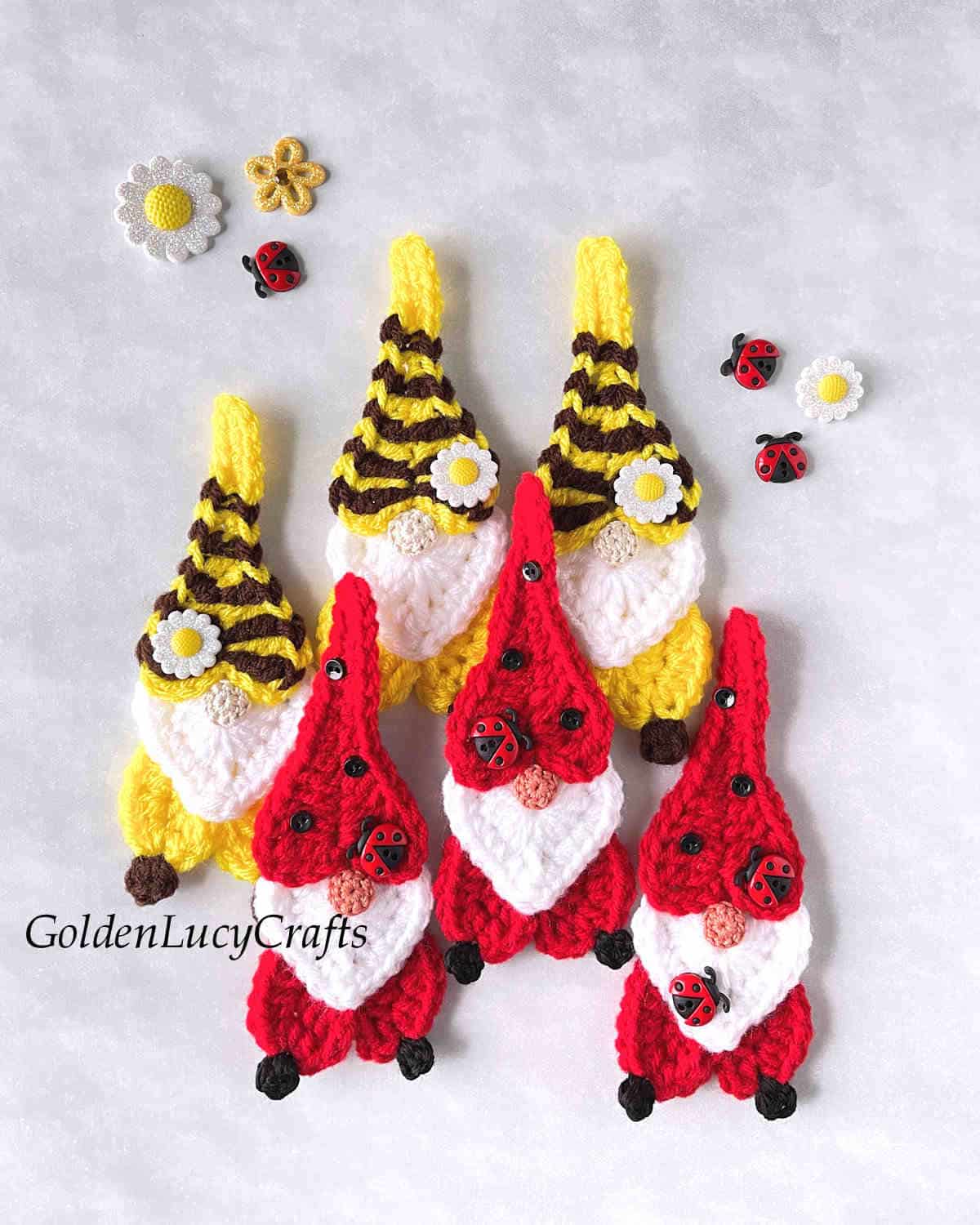 Six crocheted heart gnomes - three red and three yellow.
