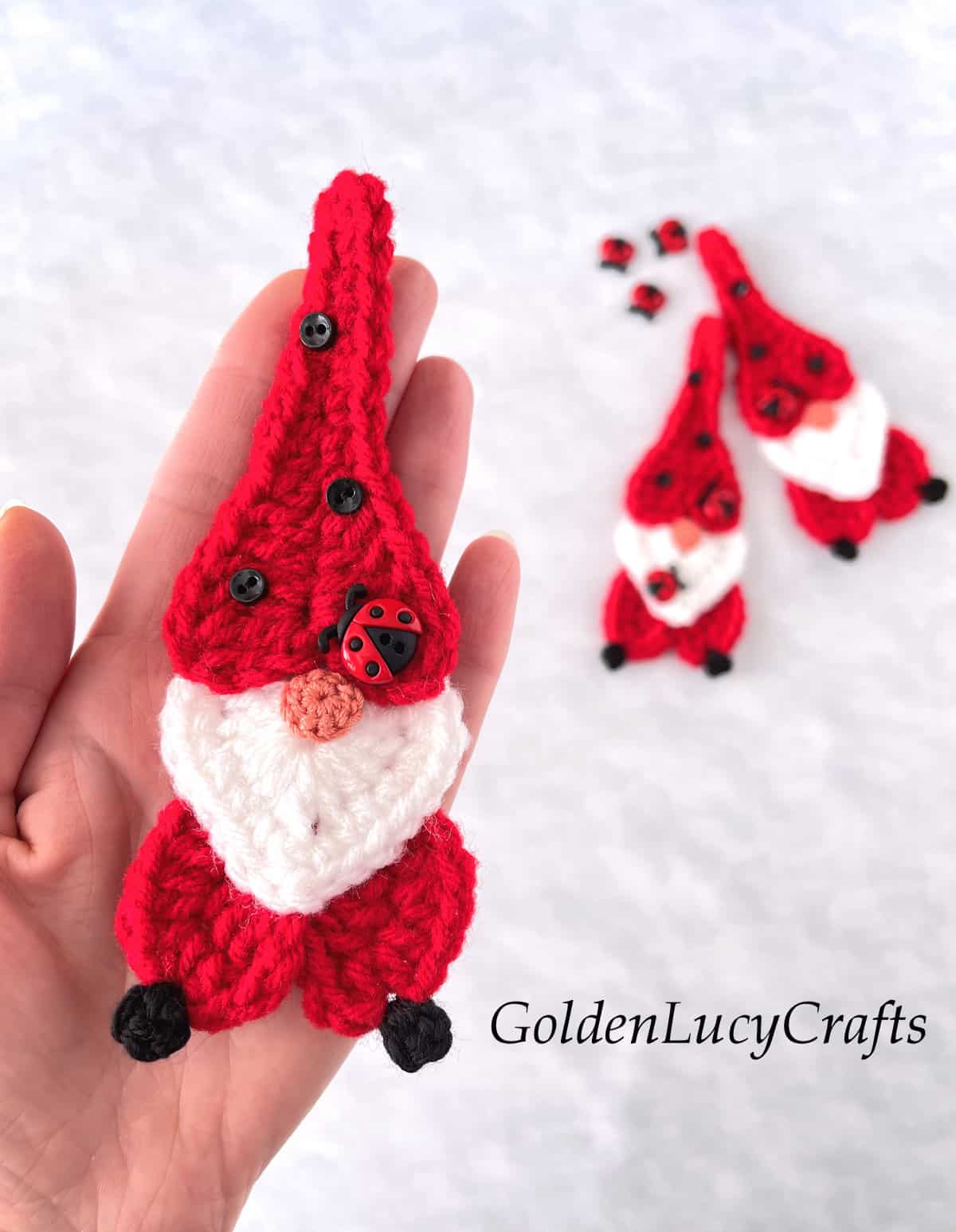 Crochet ladybug gnome in the palm of a hand.