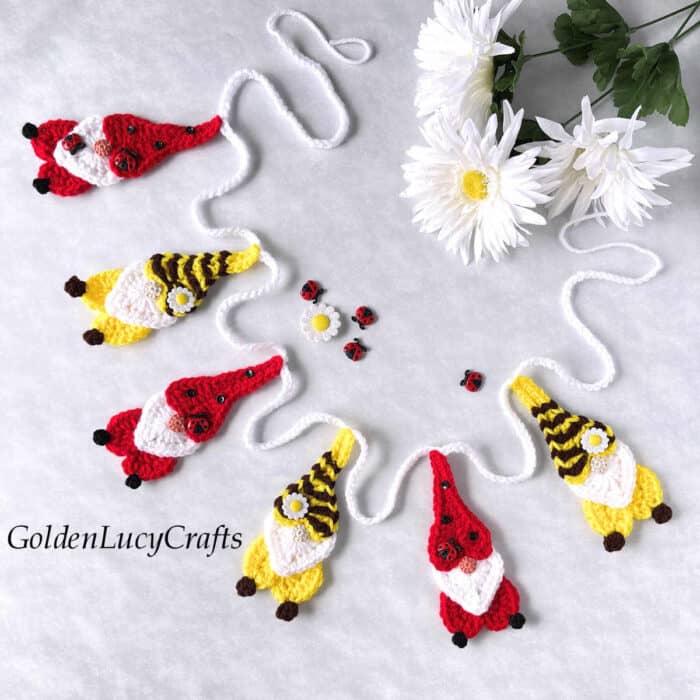 Crochet garland made from bee and ladybug gnomes.