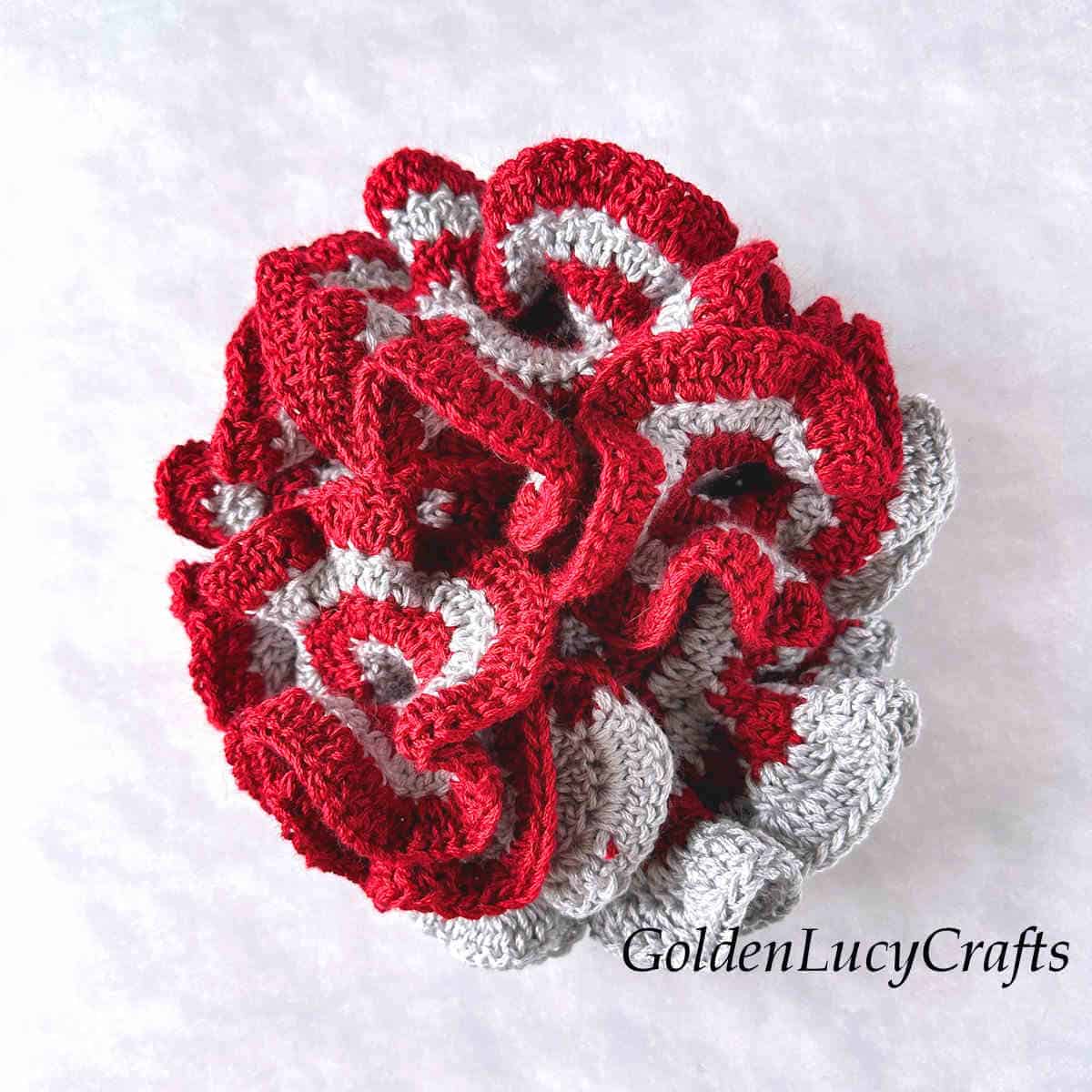 Crocheted hyperbolic coral in grey and red colors.