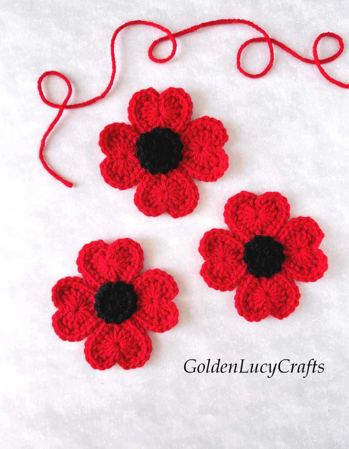 Three crocheted red poppies made from hearts.