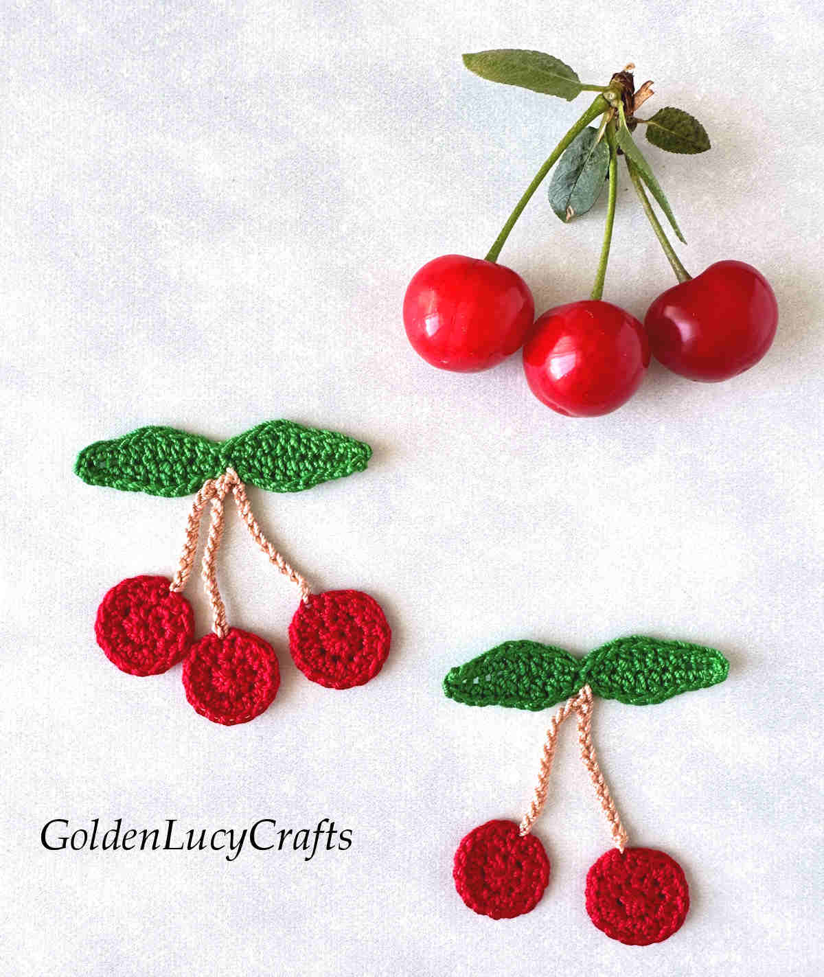 Crochet cherry appliques and three real cherries.