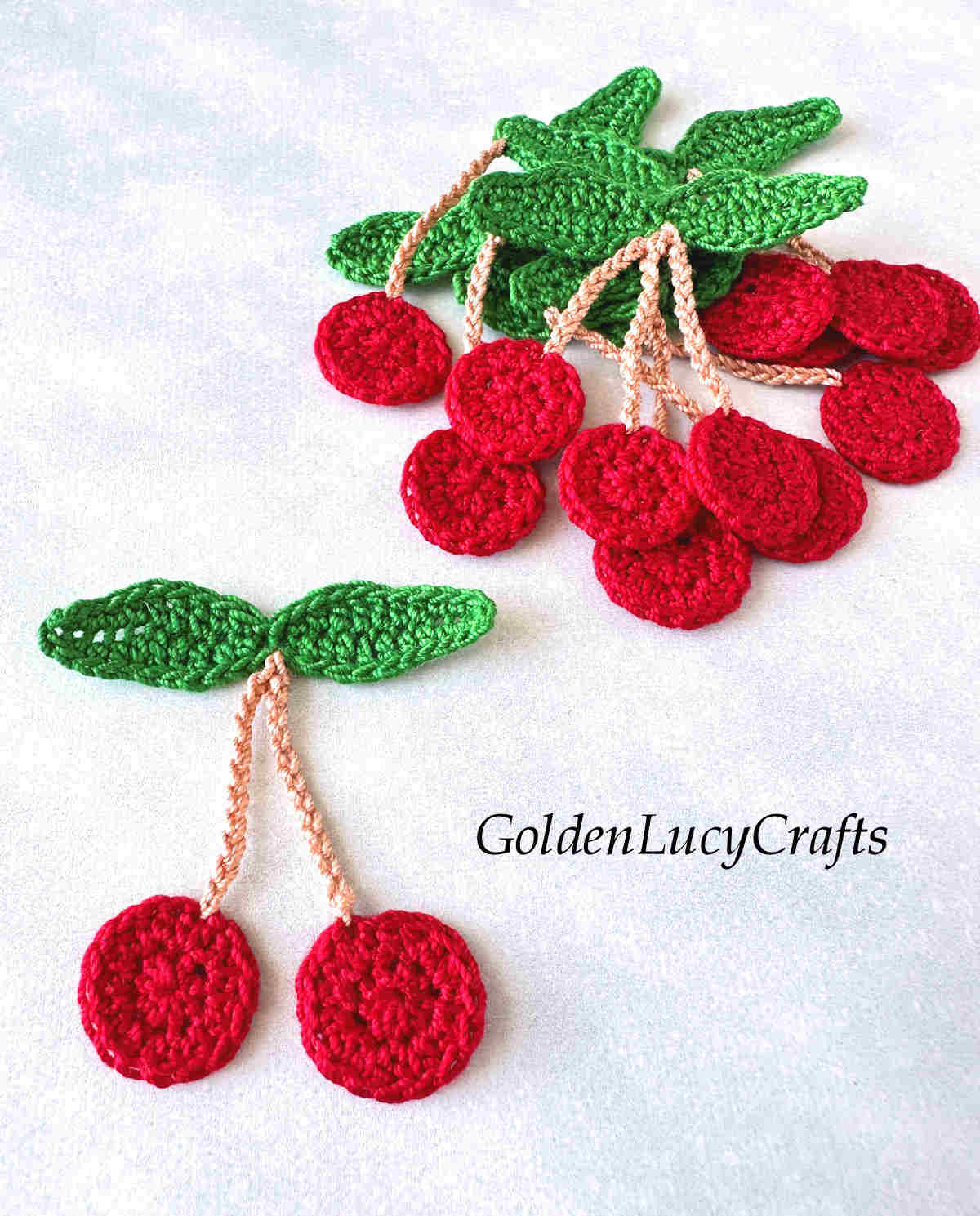 Bunch of crocheted cherry appliques.