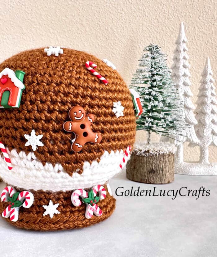 Crochet gingerbread snow globe close up picture.