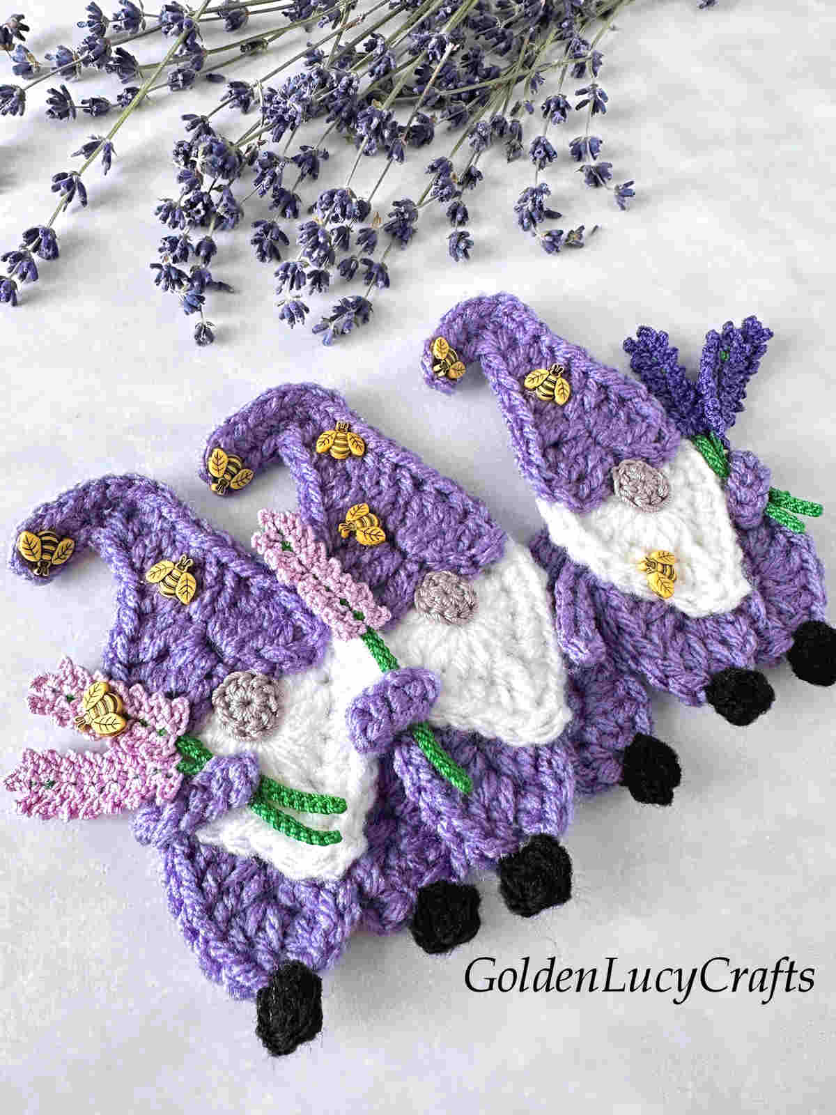 Three crocheted lavender gnomes.
