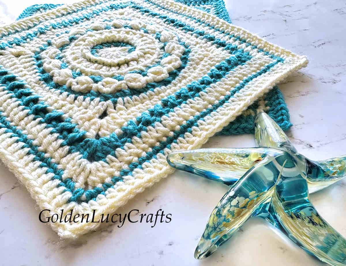Crochet square block and glass star fish close up picture.