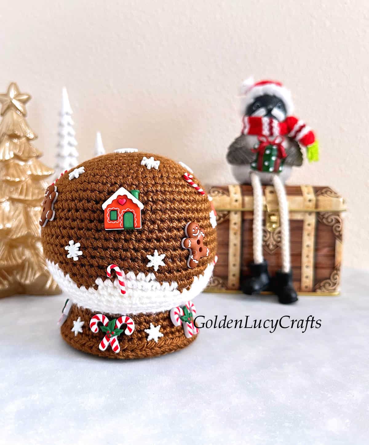 Crochet Christmas snow globe amigurumi made in brown and white colors.