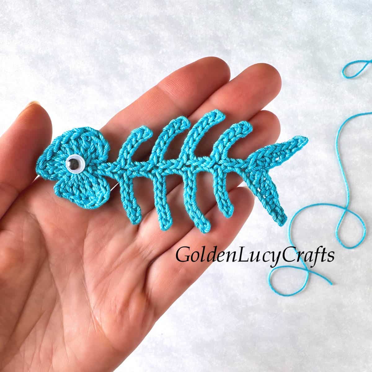 Fishbone crochet applique in the palm of a hand.