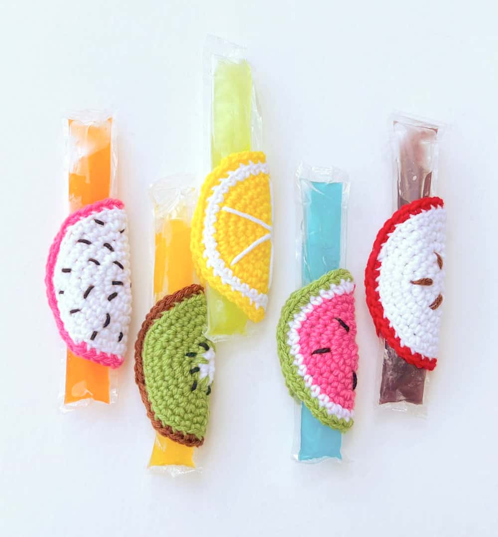 Five crocheted fruit slice popsicle holders.