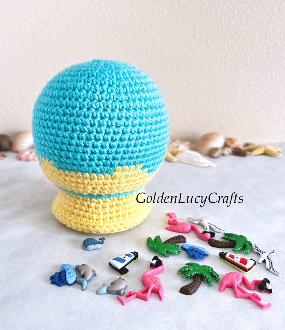 Crocheted snow globe and craft buttons laying next to it.