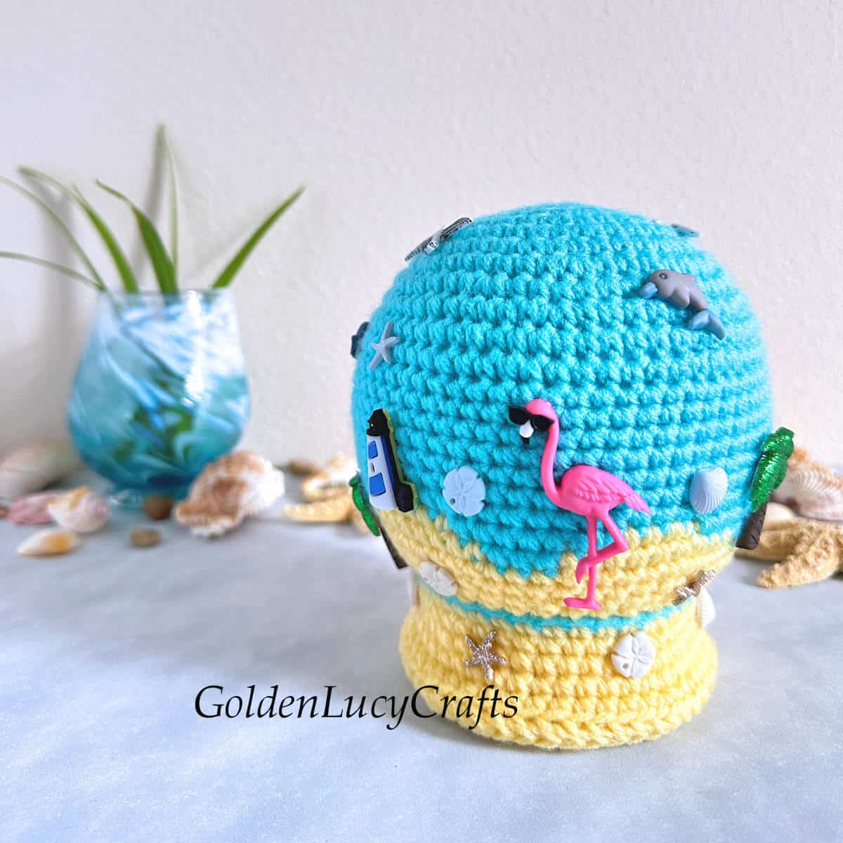 Crocheted summer beach snow globe toy embellished with craft buttons.