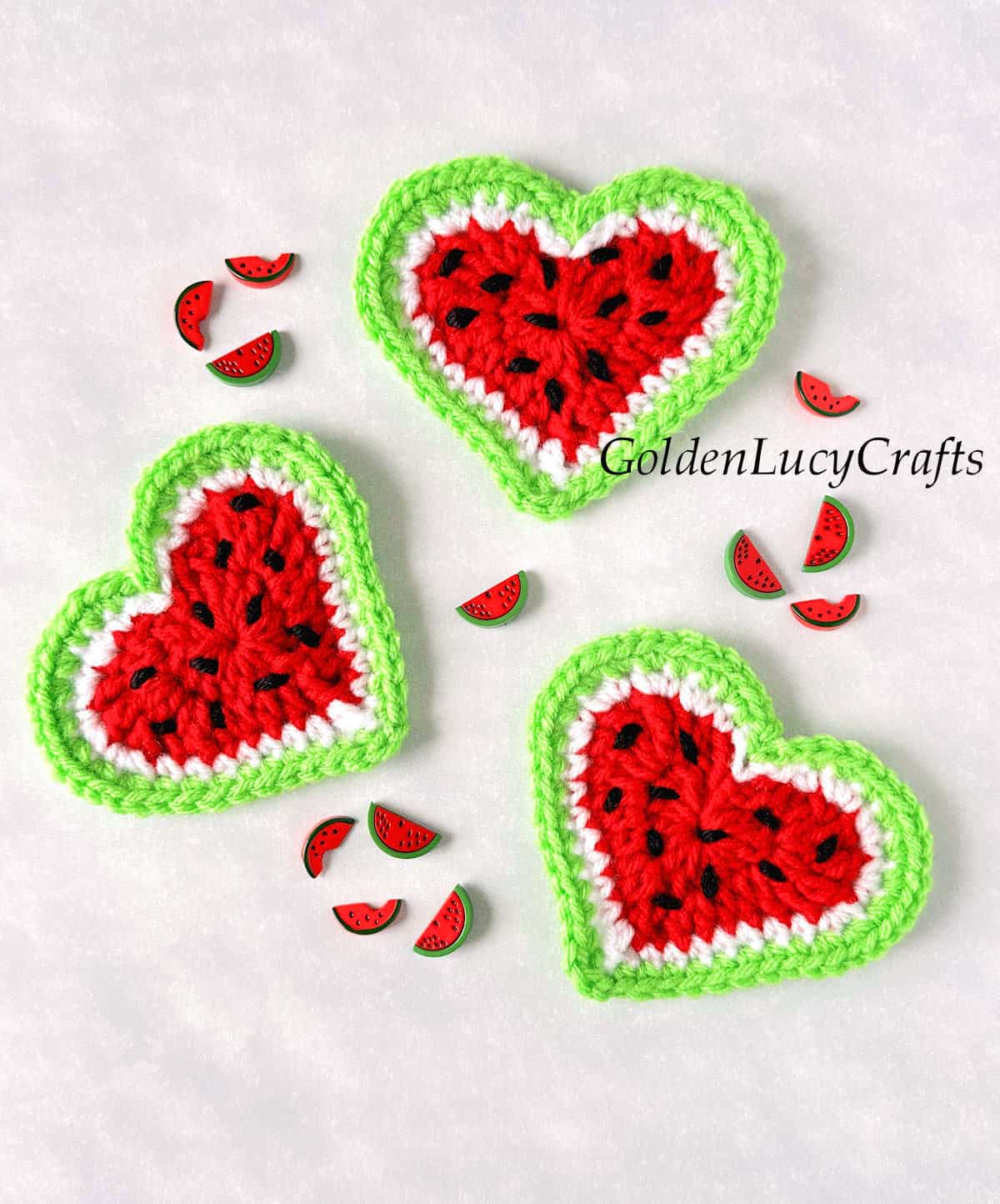 Three crochet watermelon hearts and watermelon craft buttons.