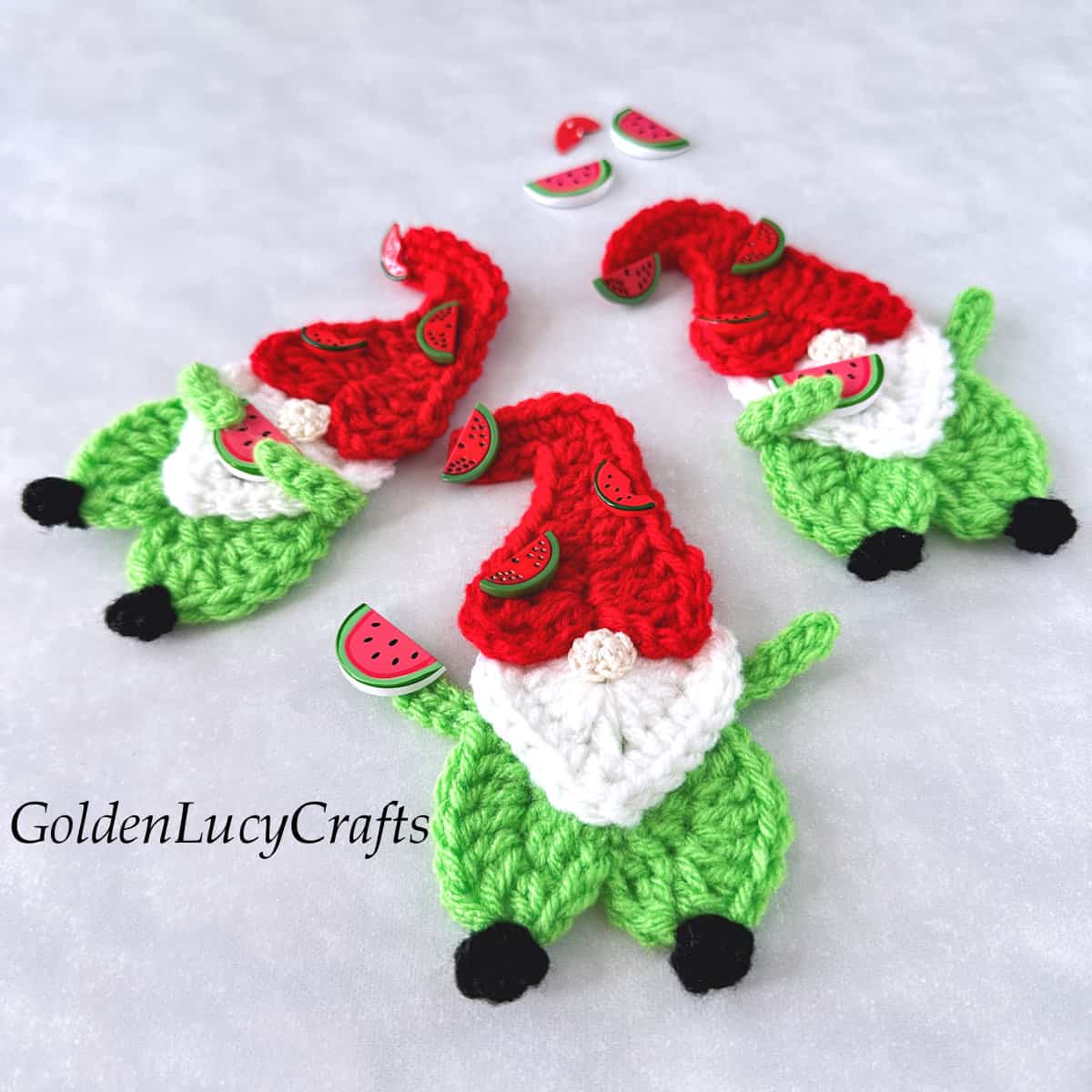 Crochet gnomes with red caps embellished with watermelon buttons.