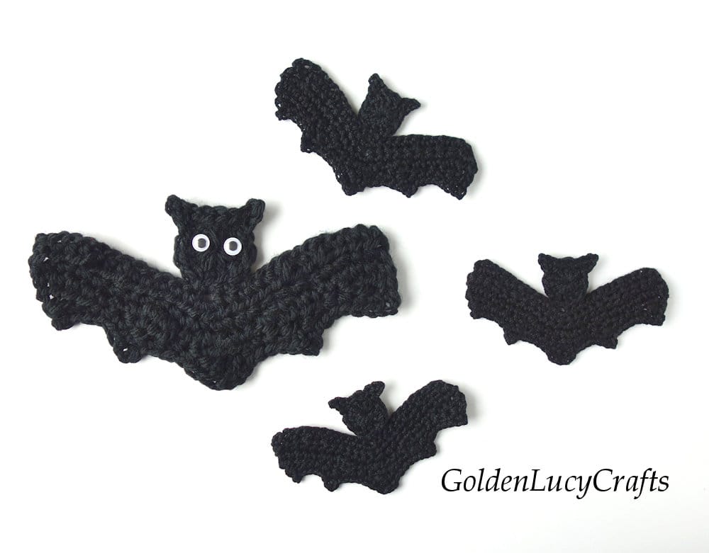 Four crocheted bat appliques.