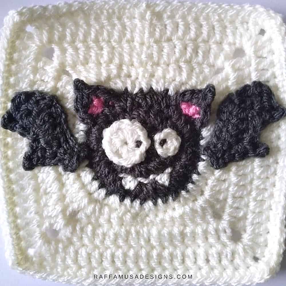Crocheted white square with bat in center.