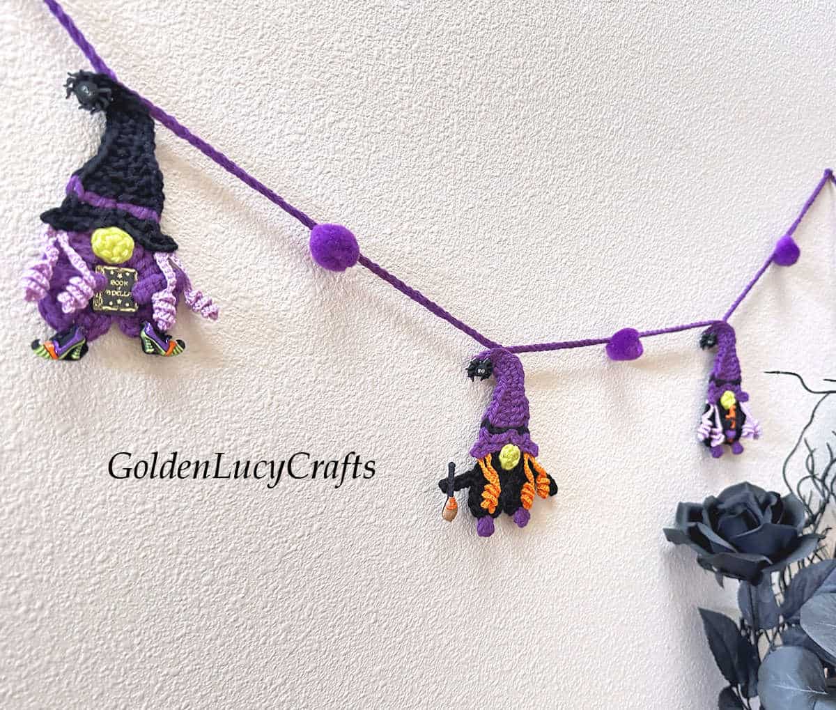 Crochet witch gnome garland on the wall.
