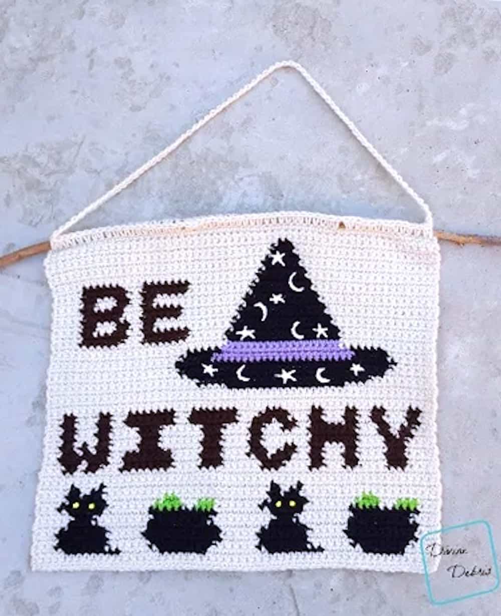 Crocheted wall hanging with the text Be Witchy on it.