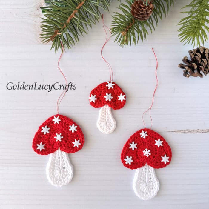 Crochet mushroom Christmas ornaments with caps embellished with tiny snowflakes.