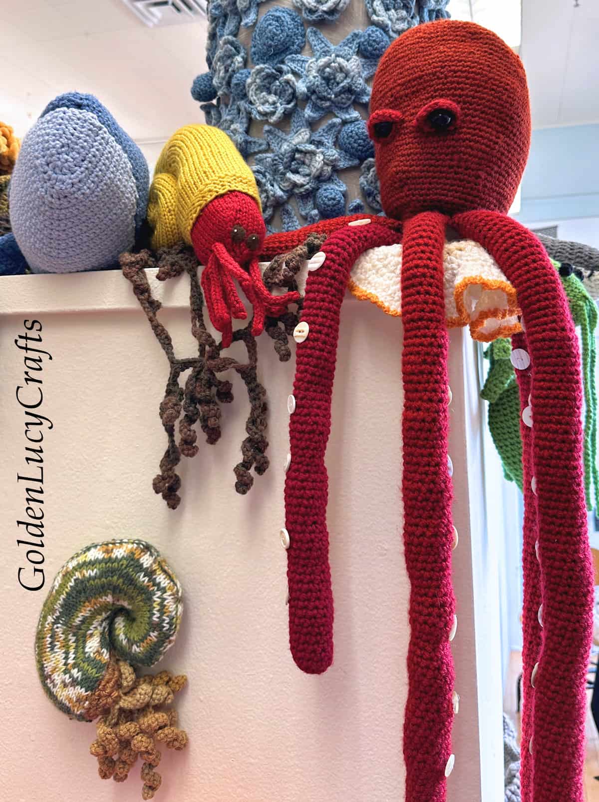 Crocheted large red octopus and other sea creatures.