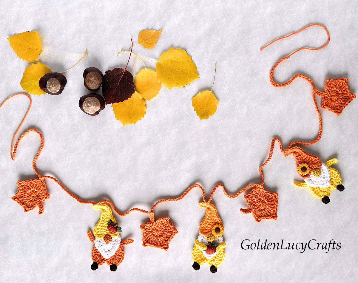 Crochet Fall garland made of leaves and gnomes embellished with fall-themed buttons.