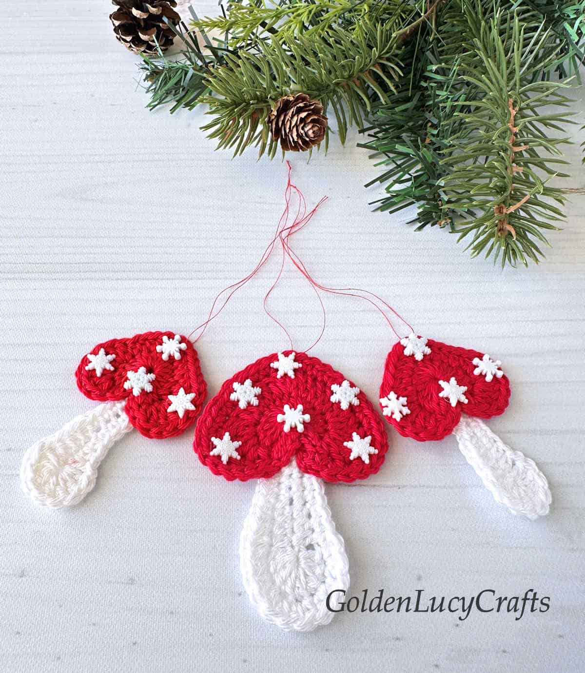 Three crocheted mushroom Christmas ornaments.