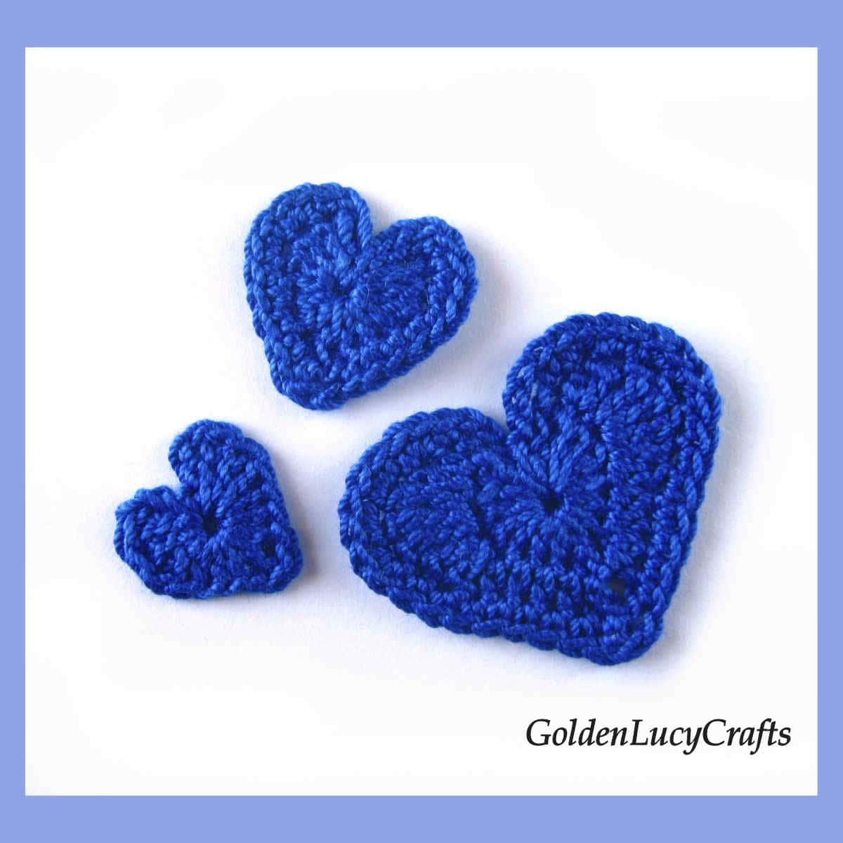 Three royal blue crochet hearts.