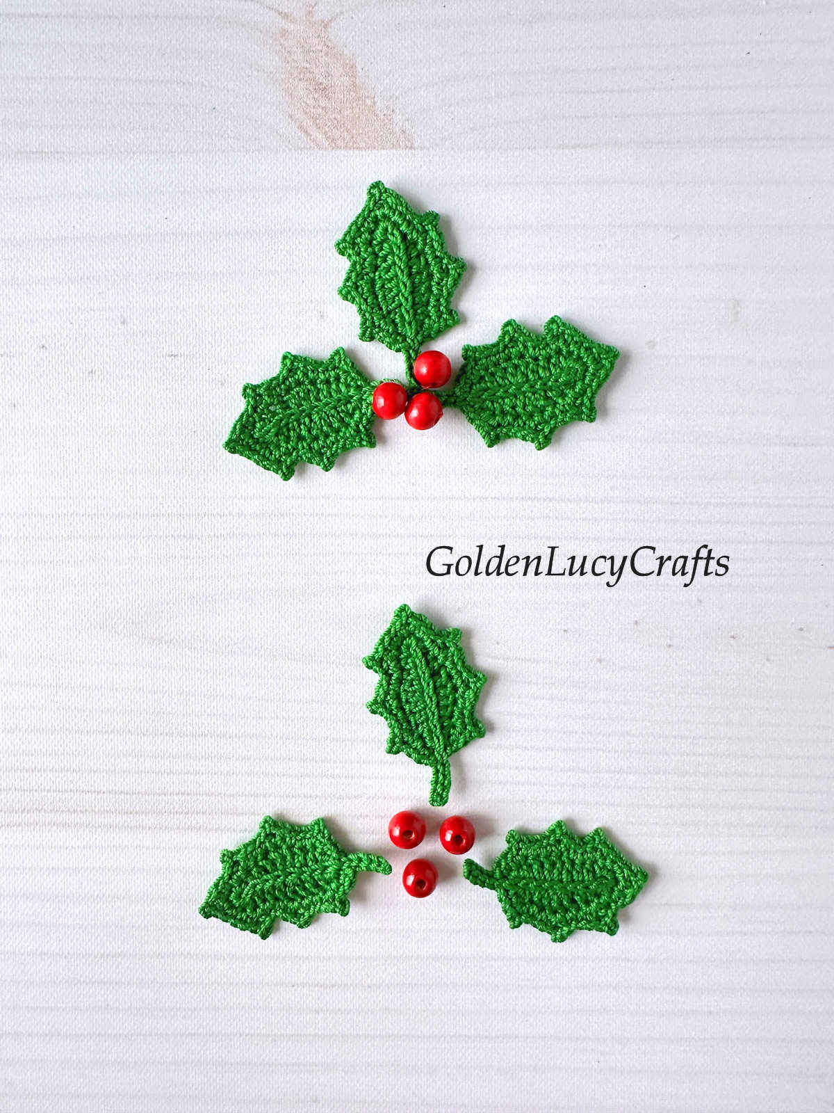 Crochet holly applique, three green holly leaves and three red beads.