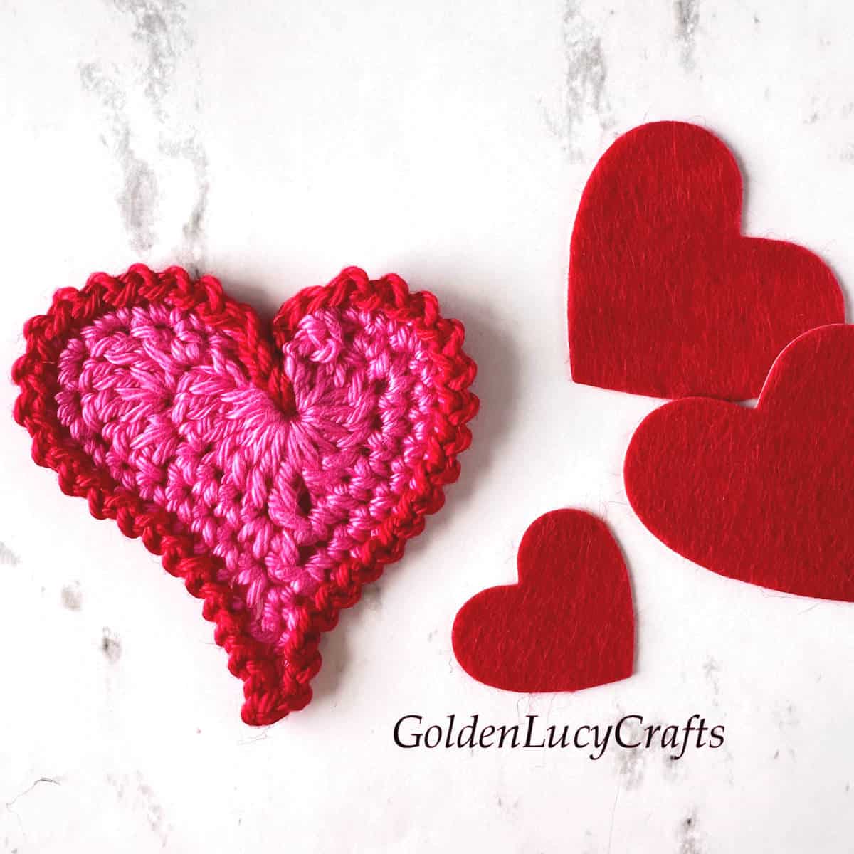 Crochet pink heart with red border.
