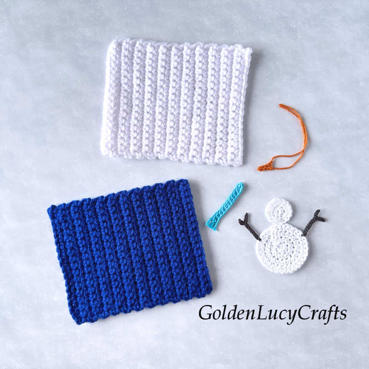 Crocheted white and blue rectangulars and parts of snowman applique.