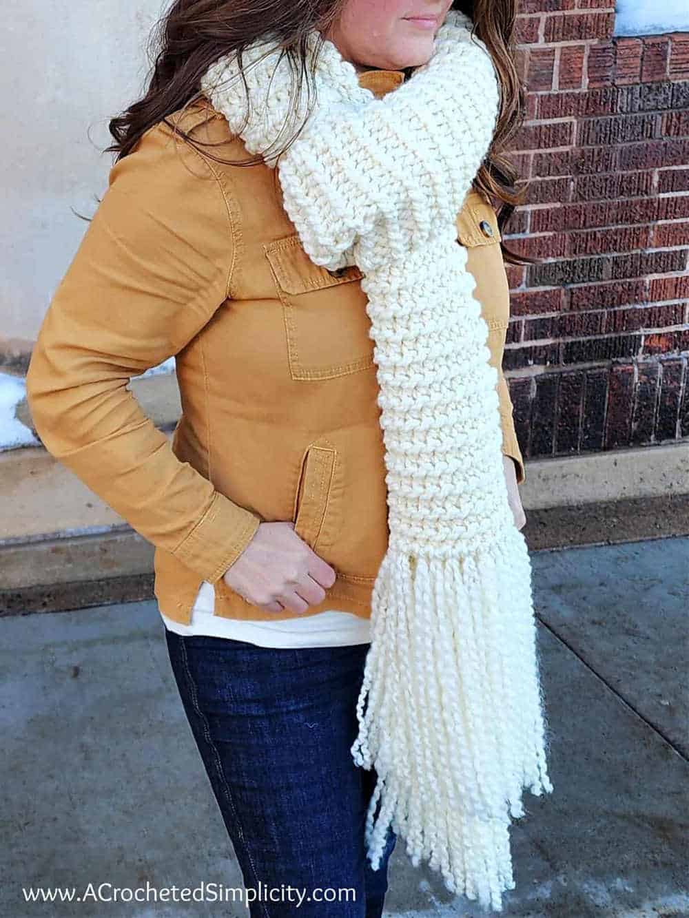 Model wearing a white crocheted scarf.