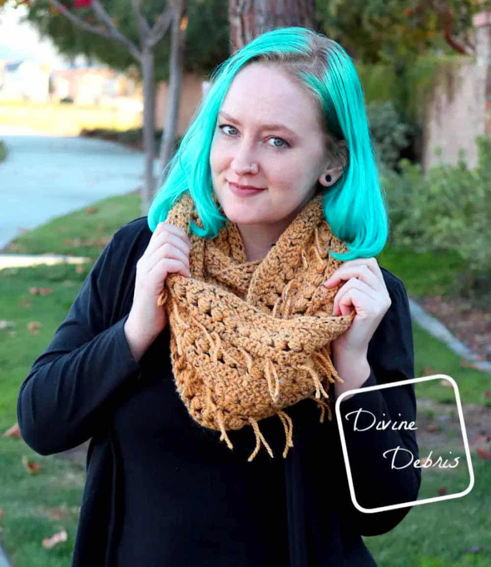 The model with blue hair dressed in a crocheted infinity scarf.