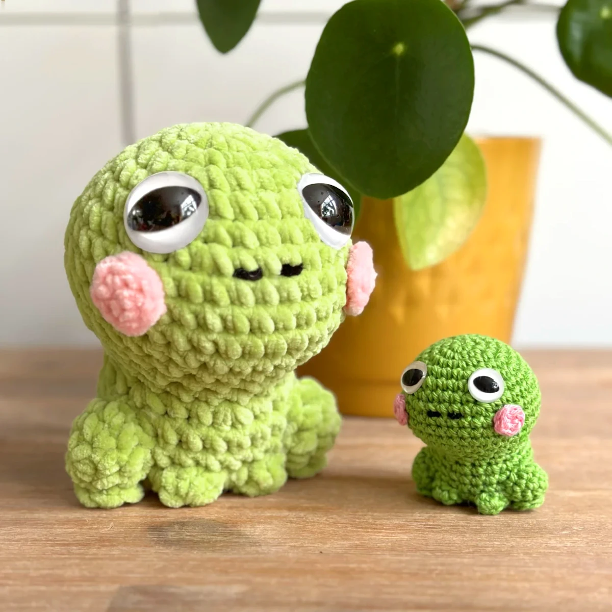 Two crocheted frog toys - large and small.