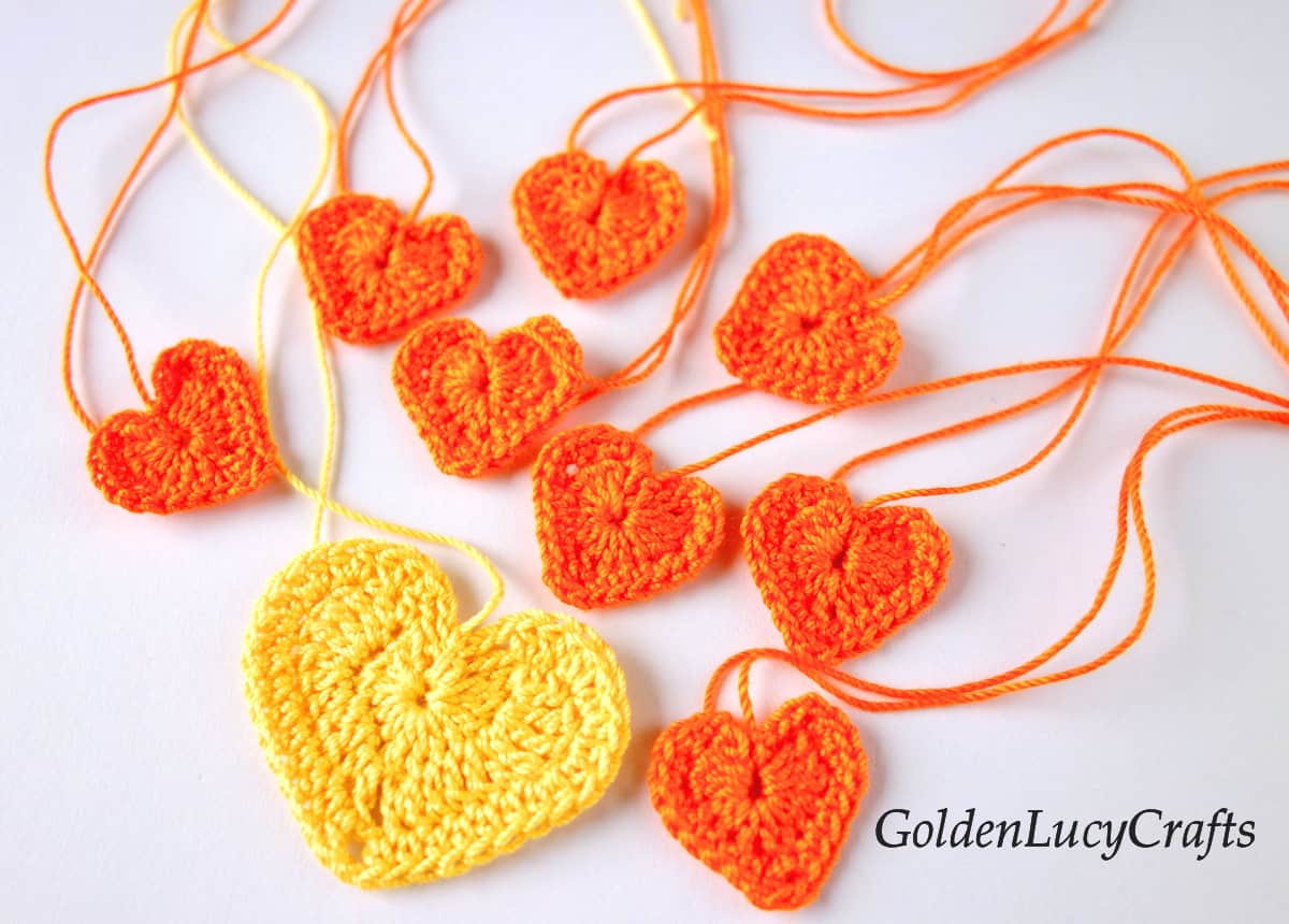 Crochet one large yellow heart and eight small orange hearts.