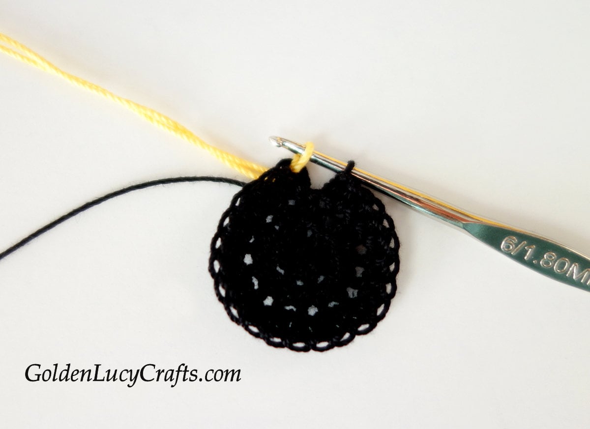 Process of joining yellow yarn to the black circle.