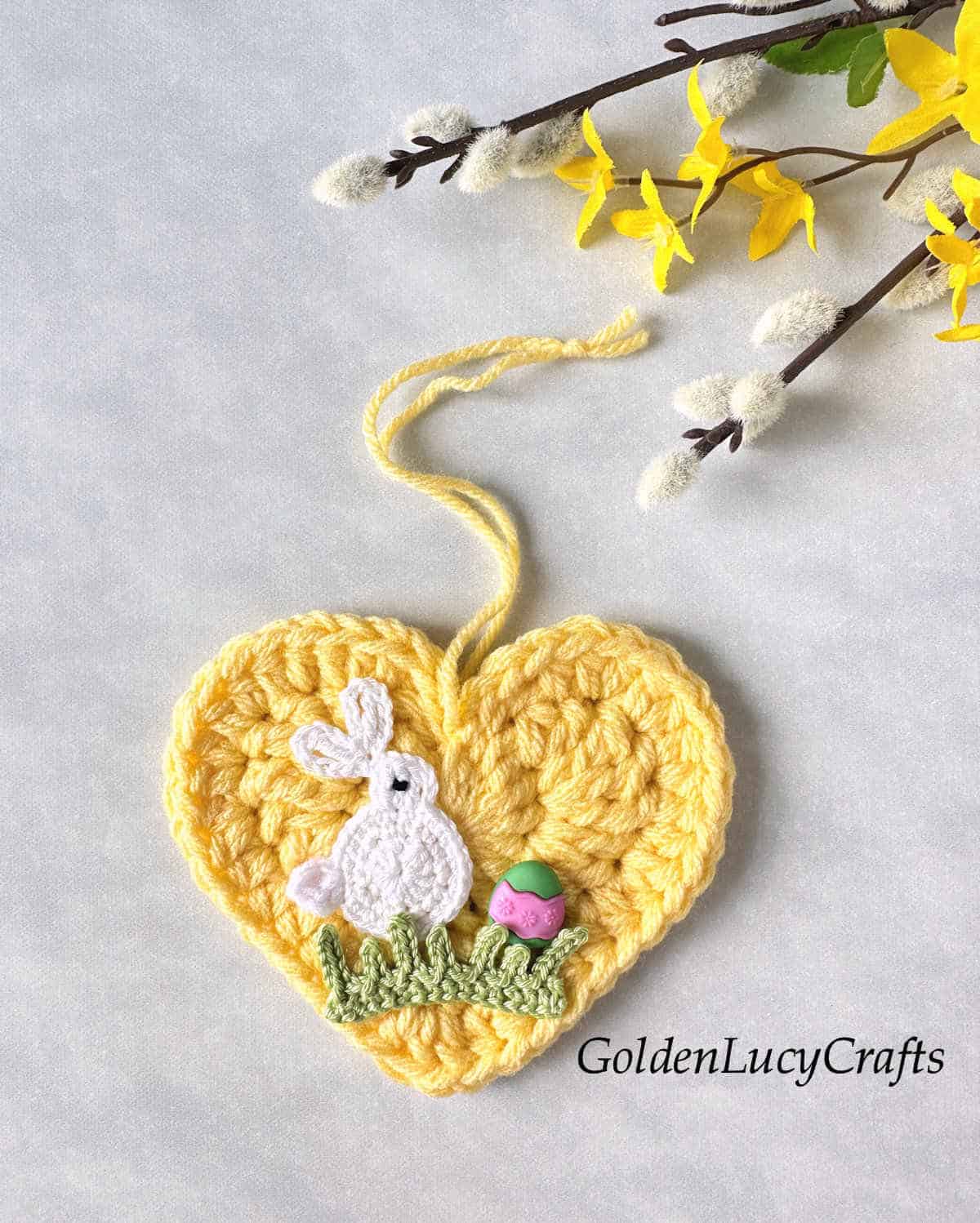 Crochet Easter heart with bunny, grass and Easter egg on it.