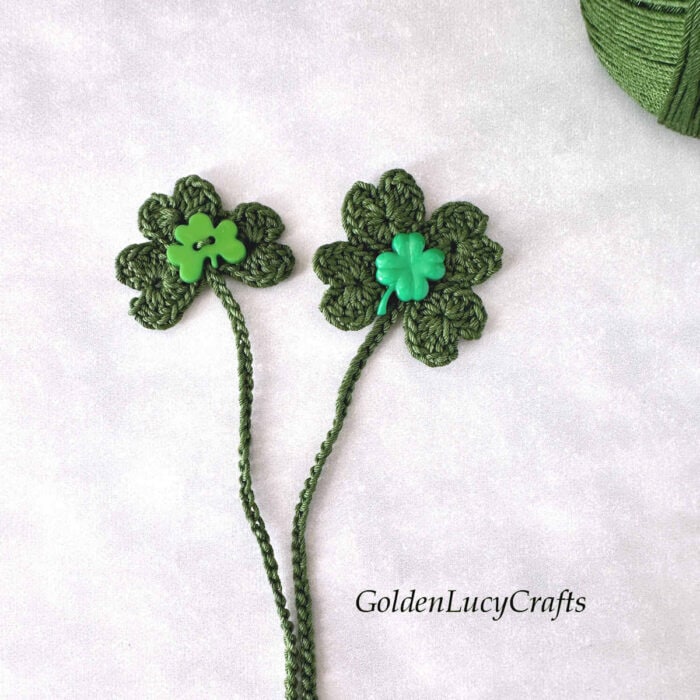 Two crochet St. Patrick's Day bookmarks embellished with decorative buttons.
