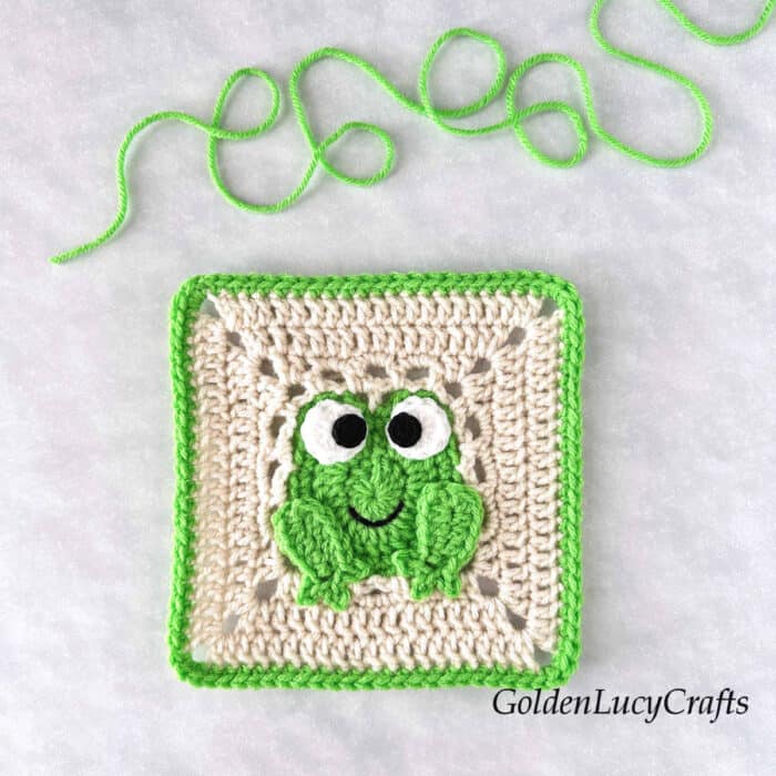 Crochet frog square with green frog in the center and green border.