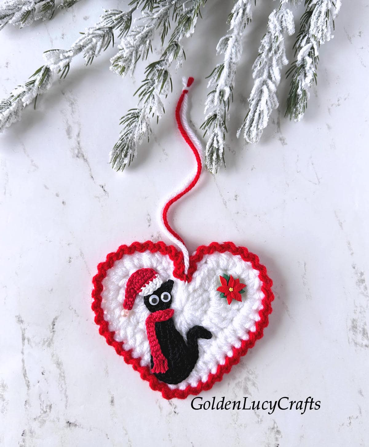 Crochet Christmas heart-shaped ornament featuring a festive black cat.