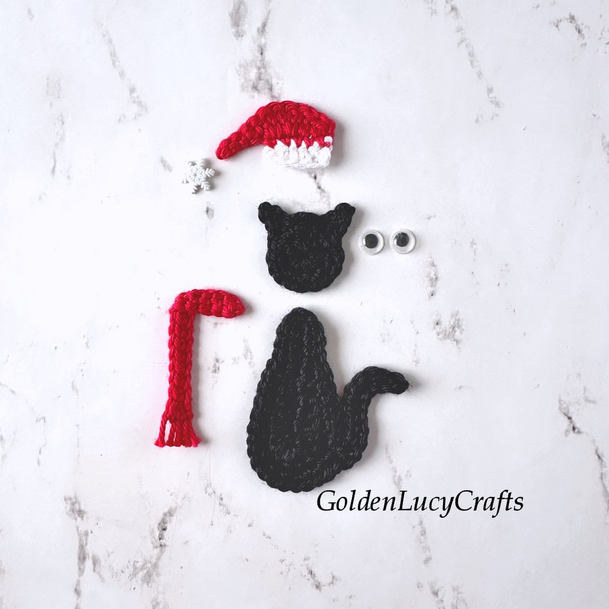 Crocheted black cat's body and head, Santa hat, red scarf, googly eyes and snowflake.